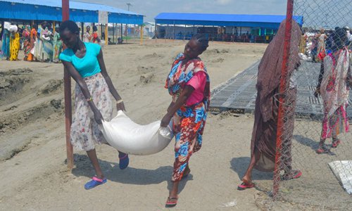 People carry food rations donated by the World Food Program (WFP) at the Malakal Protection of Civilians site in Malakal, South Sudan, June 19, 2019. (Photo by Denis Elamu/Xinhua)