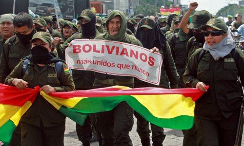 Police officers take part in a march to protest against Bolivian President Evo Morales with a sign reading 