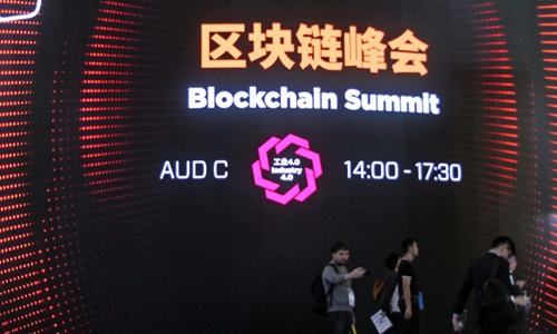 People walk by a sign of Blockchain Summit during the Mobile World Congress Shanghai 2019 in June. Photo: IC