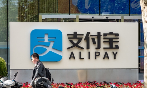 A passenger walks by an Alipay building in the Lujiazui financial center in Shanghai on Wednesday. Alipay, Alibaba's online payment platform, spent more than 2.2 billion yuan ($313 million) to purchase the building, which covers 48,000 square meters. Hangzhou-based Alipay set up a subsidiary in Shanghai in 2008 and officially settled in the city in 2015. Photo: IC