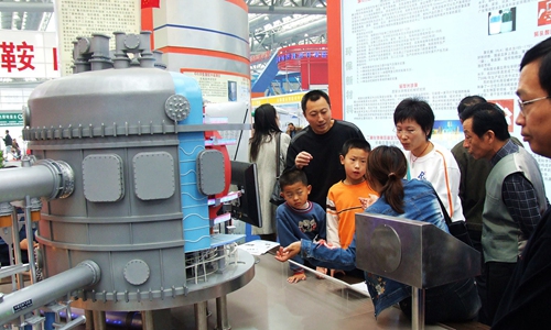 Public visit the model of artificial sun in Hefei, capital of East China’s Anhui Province in October 2006. Through the model, they can know how the machine generates electricity. Photo: VCG