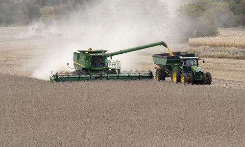 A combine and a grain cart work in a soybean field of Pellett family's farm in Atlantic, a small city in Iowa, the United States, Oct. 16, 2019. (Xinhua/Wang Ying)