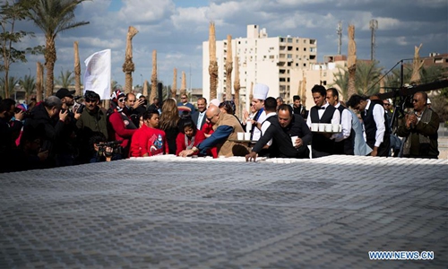 People put coffee cups to create a mosaic of ancient Egyptian King Tutankhamun's mask in Giza, Egypt, on Dec. 28, 2019. At the yard of the Grand Egyptian Museum (GEM) near the Great Pyramids of Giza, Egypt celebrated on Saturday in an open-air ceremony setting a new Guinness World Record for the largest mosaic of ancient Egyptian King Tutankhamun's mask made of coffee cups. (Xinhua/Wu Huiwo)
