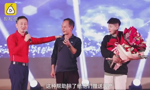 A company's leader(left) in South China's Guangdong Province presents extraordinary year-end bonus: a new apartment worth 2 million yuan ($287,000), to two employees who left their children in their rural hometowns to work for the company in the city of Dongguan. Screenshot from Pear Video