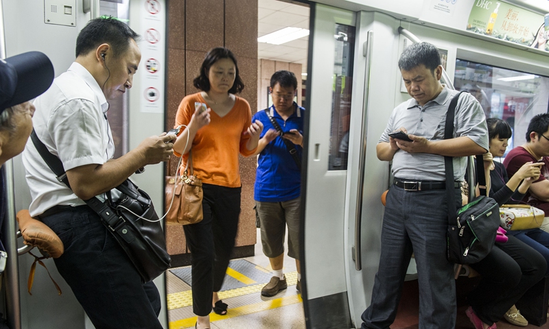 People check their phones in a Beijing subway. Photo: Li Hao/GT