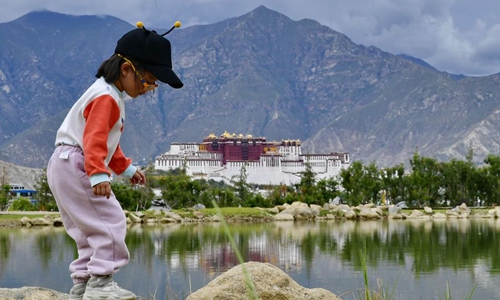 A child plays by a lake at Nanshan Park in Lhasa, southwest China's Tibet Autonomous Region, July 30, 2019.(Xinhua/Zhang Rufeng)