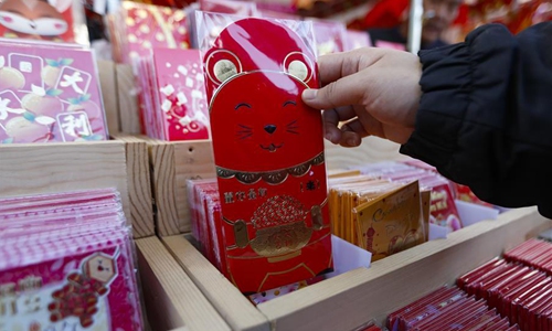 A woman purchases red envelopes at the annual Lunar New Year Flower Festival 2020 in Westminster, the United States, Jan. 11, 2020. The Flower Festival, which is held from Jan. 3 to Jan. 23, draws thousands of people every day to shop flowers and gifts, celebrating the upcoming Lunar New Year. (Xinhua/Li Ying)

