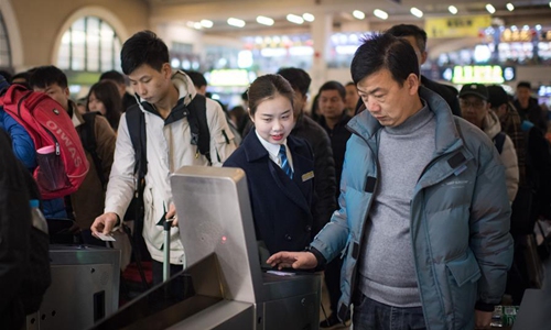Sun Fanjun (C), a ticket inspector, guides passengers through ticket gates at Hankou Railway Station in Wuhan, central China's Hubei Province, Jan. 5, 2020. China, the world's most populated country, on Jan. 10 ushered in its largest annual migration, 15 days ahead of the Spring Festival, or the Lunar New Year. This year, three billion trips will be made during the travel rush from Jan. 10 to Feb. 18 for family reunions and travel, according to official forecast. The 40-day travel rush is known as Chunyun in Chinese. The Lunar New Year falls on Jan. 25 this year, earlier than previous years, which brings a bigger challenge to the transport system as the return trips of college students overlap with the travel rush. Among all means of transportation, high-speed railway is the most favored for the Chunyun travelers. China's high-speed railway network tops the world with an estimated length of 35,000 km by the end of 2019. Traveling by high-speed rail is not merely fast but also comfortable. Facilitated by new technologies, such as online booking and face-scanning check-in service, and advanced transport facilities, people have enjoyed shortened journey time as well as pleasant convenience. But to make all these happen, a large number of railway staff have to work with their utmost efforts during this busiest period of time for the whole year. Most of them are just ordinary workers unknown by the travelers they serve. (Xinhua/Xiao Yijiu) 



