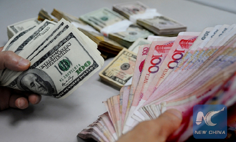 A bank officer counts banknotes. Photo:Xinhua