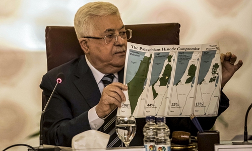 Palestinian President Mahmoud Abbas holds a placard showing maps of (from left to right) historical Palestine, the 1947 United Nations partition plan on Palestine, the 1948-67 borders between the Palestinian territories and Israel, and a current map of the Palestinian territories without Israeli-annexed areas and settlements, as he attends an Arab League emergency meeting discussing the US-brokered proposal for a settlement of the Middle East conflict at the league's headquarters in the Egyptian capital Cairo on Saturday. Photo: AFP