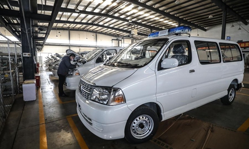 A worker examines new ambulances at the manufacturing base of the Brilliance Auto company in Shenyang, northeast China's Liaoning Province, Feb. 3, 2020. (Xinhua/Pan Yulong)