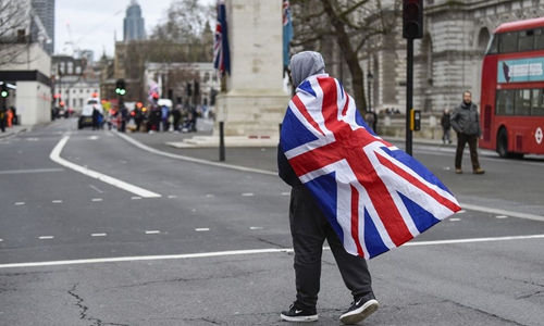 A supporter of a pro-Brexit group walks down Whitehall in London, Britain, on Jan. 31, 2020. (Photo by Stephen Chung/Xinhua)