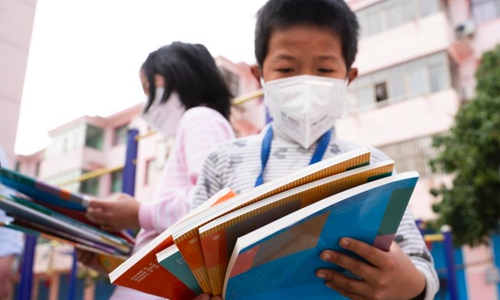 Primary students receive text books for the new semester at their homes in Xinyu city, East China's Jiangxi province, Feb 26, 2020. Chinese schools have suspended the new semester and moved the classrooms online because of the novel coronavirus outbreak. (Photo: China News Service/Zhao Chunliang)