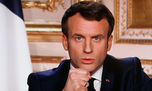 French President Emmanuel Macron is seen on a television screen as he speaks during a televised address to the nation on the outbreak of COVID-19, caused by the novel coronavirus on Monday in Paris. Photo: AFP