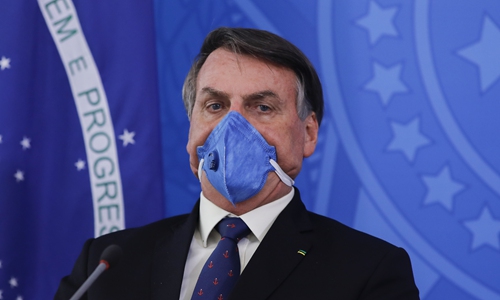 Brazilian president Jair Bolsonaro wears a face mask during a press conference on the coronavirus pandemic COVID-19 at the Planalto Palace in Brasilia, Brazil on Friday. Photo: AFP
