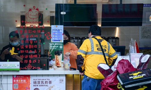 A deliveryman of Meituan Dianping, a Chinese group buying platform, waits outside a milk tea store in Wuhan on Friday, central China's Hubei Province. Restaurants and stores have gradually reopened in Wuhan after the city was on lockdown for nearly two months.  Photo: IC