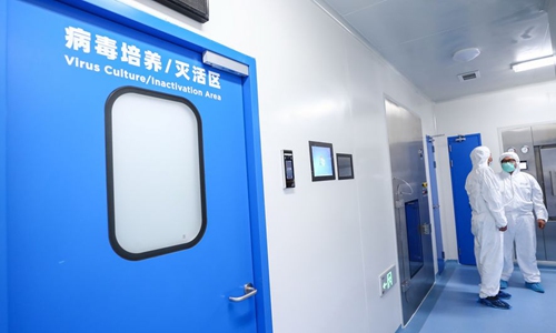 Staff members talk beside the virus culture/inactivation area of a vaccine production plant of China National Pharmaceutical Group (Sinopharm) in Beijing, capital of China, April 10, 2020. Photo:Xinhua