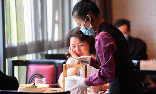 A staff member presents a serving spoon at a Hunan cuisine restaurant in Yuelu District of Changsha, central China's Hunan Province, April 15, 2020. As the COVID-19 epidemic has been subdued, catering companies in Changsha have reopened recently under strict measures taken to ensure the food security. (Xinhua/Chen Zeguo)