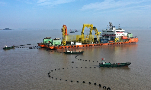 An aerial photo taken on Monday shows the latest section of submarine cable being towed to Yushan Island in Zhoushan, East China's Zhejiang Province. The 18.35-kilometer cable, the second for the island, was completed on Sunday. There will be nine submarine cables for the island in total. Photo: cnsphoto