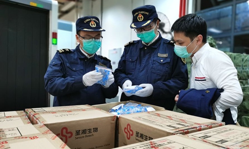 Customs officers carry out routine inspections on the testing kits that are bound for overseas clients in Changsha, capital of central China's Hunan Province, March 25, 2020. (Photo provided to Xinhua)
