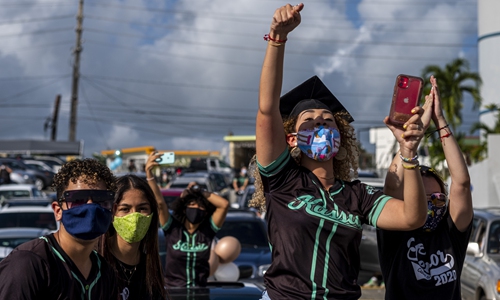 Graduating students from the Ramon Power Y Giralt High School wear face masks during a symbolic graduation from their cars to maintain social distance at a parking lot in Las Piedras, Puerto Rico on Wednesday. The event was organized by the municipal government to congratulate the local graduates whose traditional ceremonies were canceled due to the coronavirus pandemic, with the condition of staying inside their vehicles. Photo: AFP