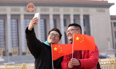 Visitors pose for a selfie with Chinese national flags in front of the Great Hall of the People in Beijing. The hall will host several events at the annual two sessions, including the plenary meetings of China's top legislative body and political advisory body. Photo: IC