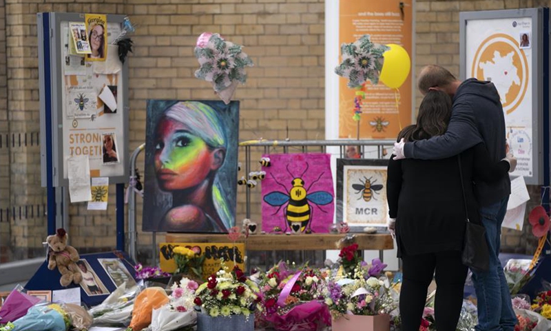 People grieve at a memorial of the Manchester Arena attack in Manchester, Britain, May 22, 2020. Manchester on Friday marked the third anniversary of the terrorist attack which killed 22 people and injured hundreds. The attack happened when Salman Abedi detonated a bomb at the end of a concert by U.S. pop singer Ariana Grande on May 22, 2017. (Photo by Jon Super/Xinhua)