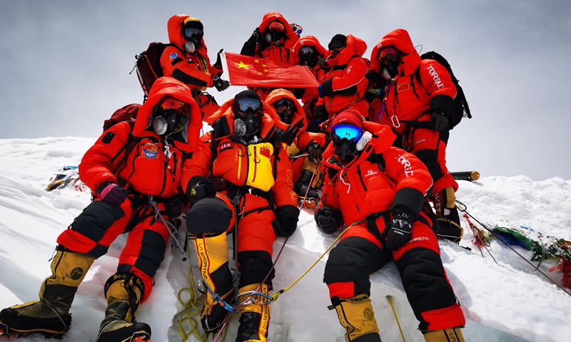 Chinese surveyors pose for a group photo atop Mount Qomolangma on Wednesday. The surveying team reached the summit on Wednesday with the trek being a crucial step in the country's mission to re-measure the height of the world's tallest peak. Photo: Xinhua 