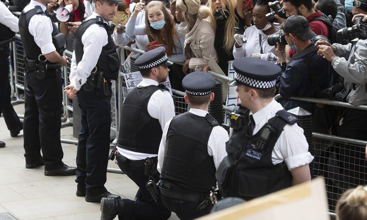 Two policemen kneel down in front of protesters outside Downing Street in London, Britain, on June 3, 2020. Thousands of people gathered in London on Wednesday to protest over the death of George Floyd, an unarmed black man suffocated to death by a white police officer in the mid-western U.S. state of Minnesota last week. (Photo by Ray Tang/Xinhua)
