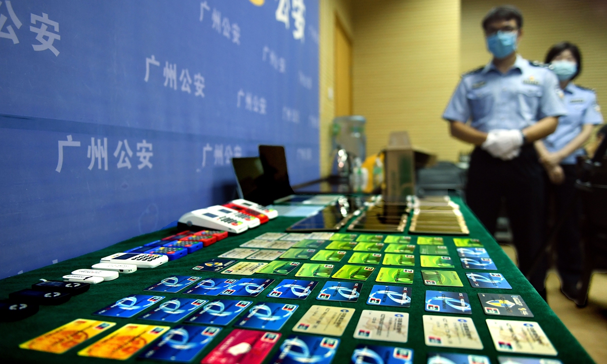 Police officers in South China's Guangdong Province on Monday display mobile phones and bankcards they seized from an internet fraud ring. The police spent six months tracing and destroying the ring, whose members had hidden in South China's Hainan Province and Southwest China's Sichuan Province. Photo: cnsphoto