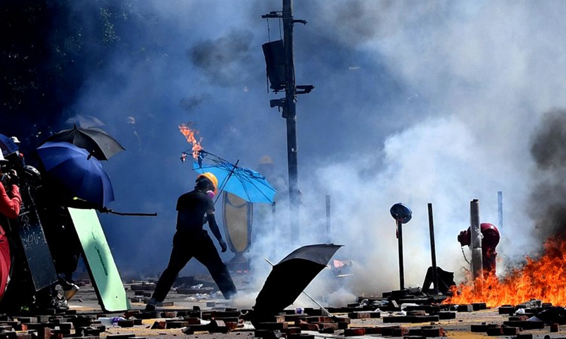 A rioter sets fire and destroys public facilities outside the Hong Kong Polytechnic University in south China's Hong Kong, Nov. 17, 2019. Photo:Xinhua