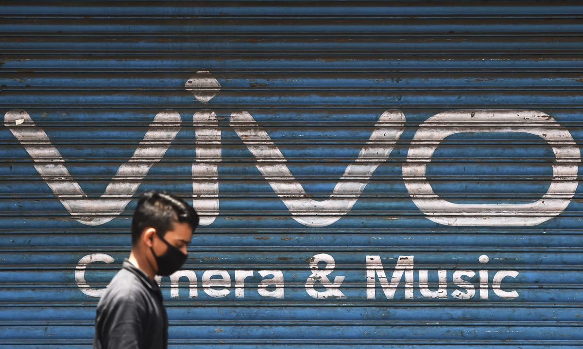 A man walks past an advertisement of Chinese mobile phone maker VIVO, in Mumbai on June 22. Photo:AFP