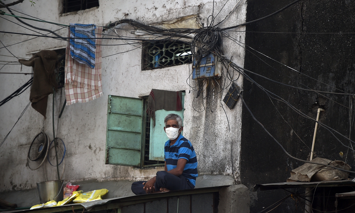 A man wearing a face mask sits on a roof in the Dharavi slum during a government-imposed nationwide lockdown as a preventive measure against coronavirus, in Mumbai, India on April 16. Photo: AFP