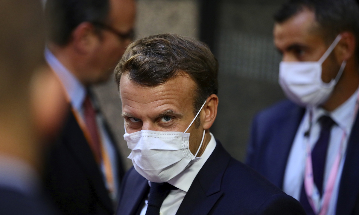 French President Emmanuel Macron leaves the European Council building in the early morning during an EU summit in Brussels, on Monday. Photo: AFP