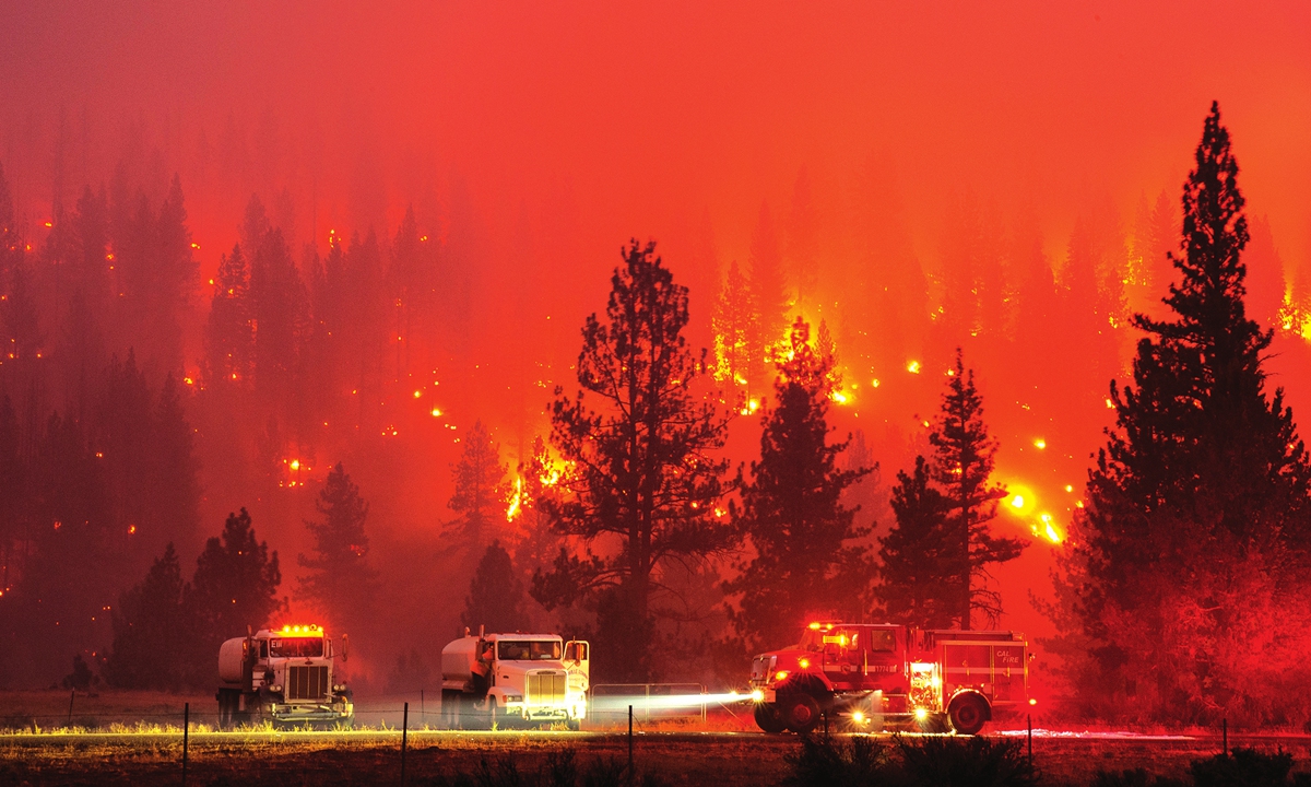 In this long exposure photograph, firefighters mop up hot spots from the wild fire along highway 36, near Susanville, California on Monday. The fire spread to more than 6,000 acres and created its own weather, generating lightning, thunder, rain and fire whirls out of a huge pyrocumulonimbus ash plume. Photo: AFP