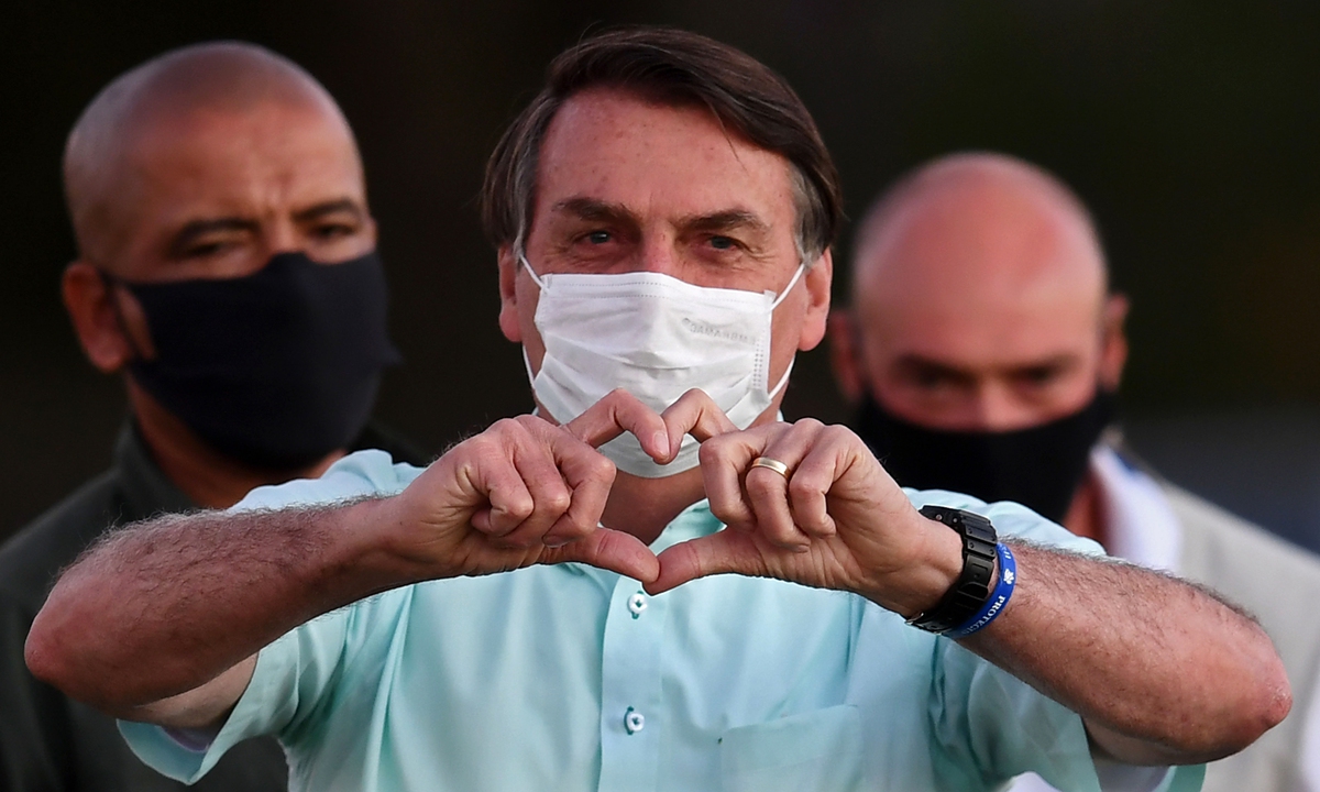Brazilian President Jair Bolsonaro makes a heart's shape with his hands to supporters outside Alvorada Palace in Brasilia on Wednesday. Photo: AFP