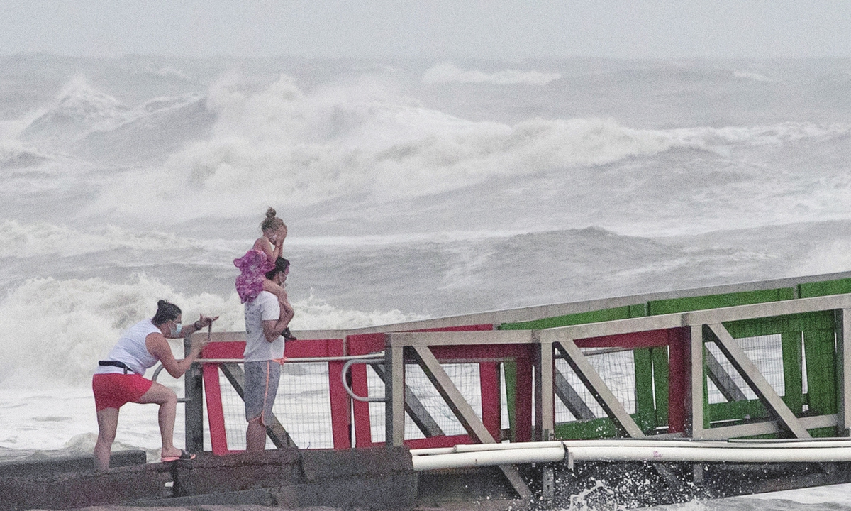 A family watches high swells from Hurricane Hanna from a jetty in Galveston, Texas, the US on Saturday. Photo: VCG