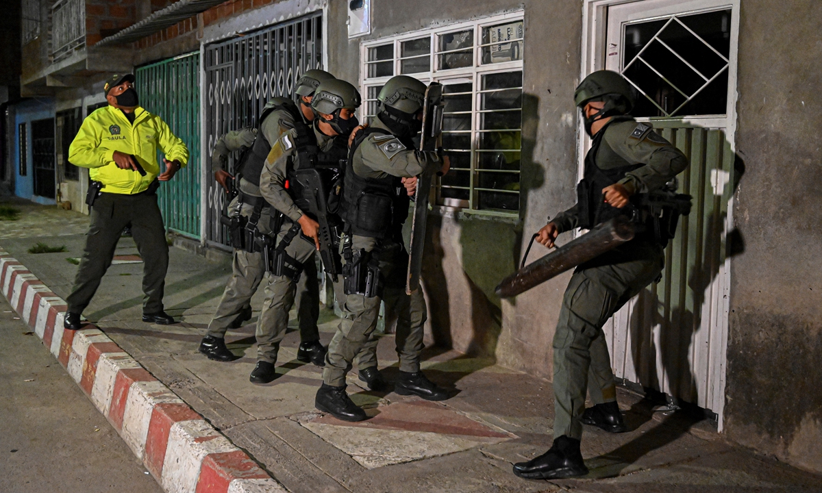 Colombian police of the GOES Special Operations Group, break down a door on Wednesday in Cali, Colombia, during an operation against criminal gangs and drug traffickers in the Aguablanca District, one of the most dangerous areas of the city. Photo: AFP