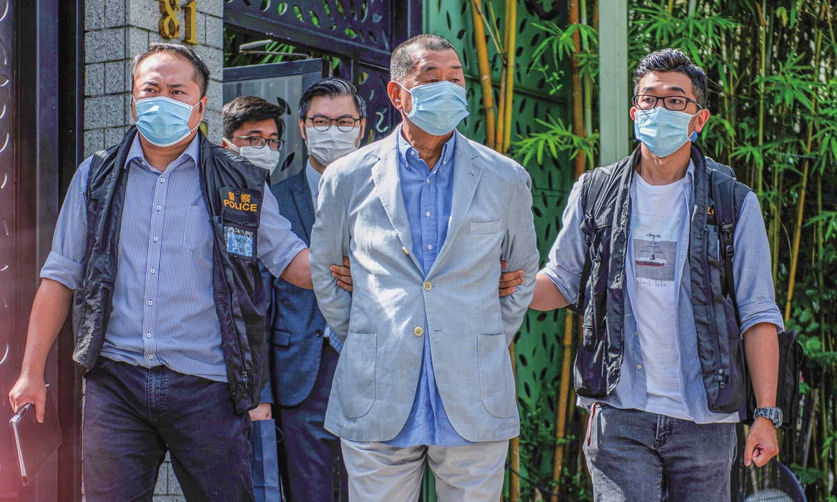 Hong Kong police lead Jimmy Lai Chee-ying, one of the most high-profile Hong Kong secessionists, away from his home after he was arrested on Monday under the new national security law for Hong Kong. Photo: AFP