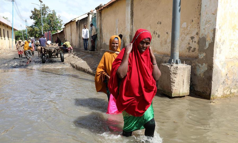 People wade through a flooded road in Afgoye, Somalia, Aug. 9, 2020. More than 150,000 Somalians have fled their homes since June due to flash and riverine flooding in the southern regions of this Horn of Africa nation, Farhan Haq, deputy spokesman for UN Secretary-General Antonio Guterres, told journalists at a virtual press briefing on Friday. (Photo by Hassan Bashi/Xinhua) 