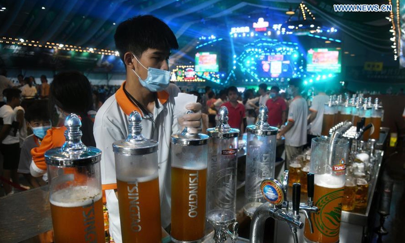 A staff member serves beer for customers during the 30th Qingdao International Beer Festival in Qingdao, east China's Shandong Province, Aug. 16, 2020. The 17-day beer festival, hosting visitors with 1,500 kinds of beer from more than 40 countries and regions under intensified COVID-19 prevention and control measures, concluded on Sunday. (Xinhua/Li Ziheng) 