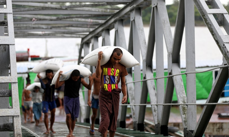 Laborers carry rice bags at a jetty in Yangon, Myanmar, Aug. 6, 2020. Myanmar exported over 2.25 million tons of rice and broken rice as of July 17 this fiscal year (FY) 2019-2020, according to a release from the Myanmar Rice Federation on Wednesday. (Xinhua/U Aung)