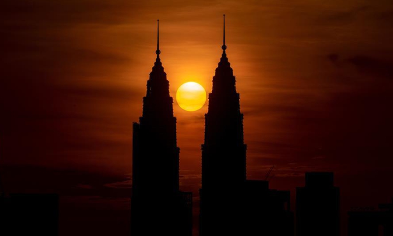 Photo taken on Oct. 15, 2019 shows the Petronas Twin Towers being silhouetted against the rising sun in Kuala Lumpur, Malaysia. Kuala Lumpur is the capital and largest city of Malaysia. Developing from a tin-mining town, the city is now widely recognised for numerous landmarks, including the Petronas Twin Towers. The combination of skyscrapers and historical sites and the harmonious coexistence of diversified cultures add to the city a special charm of its own. (Photo by Chong Voon Chung/Xinhua)
