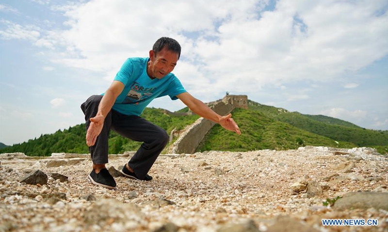 Li Dewang tells about his finding of an ancient stele about the building of the Xuliukou Great Wall, while standing on the top of one of the Great Wall's watchtowers at Xuliukou Village in Qian'an City, north China's Hebei Province, Sept. 4, 2020. (Xinhua/Mu Yu)