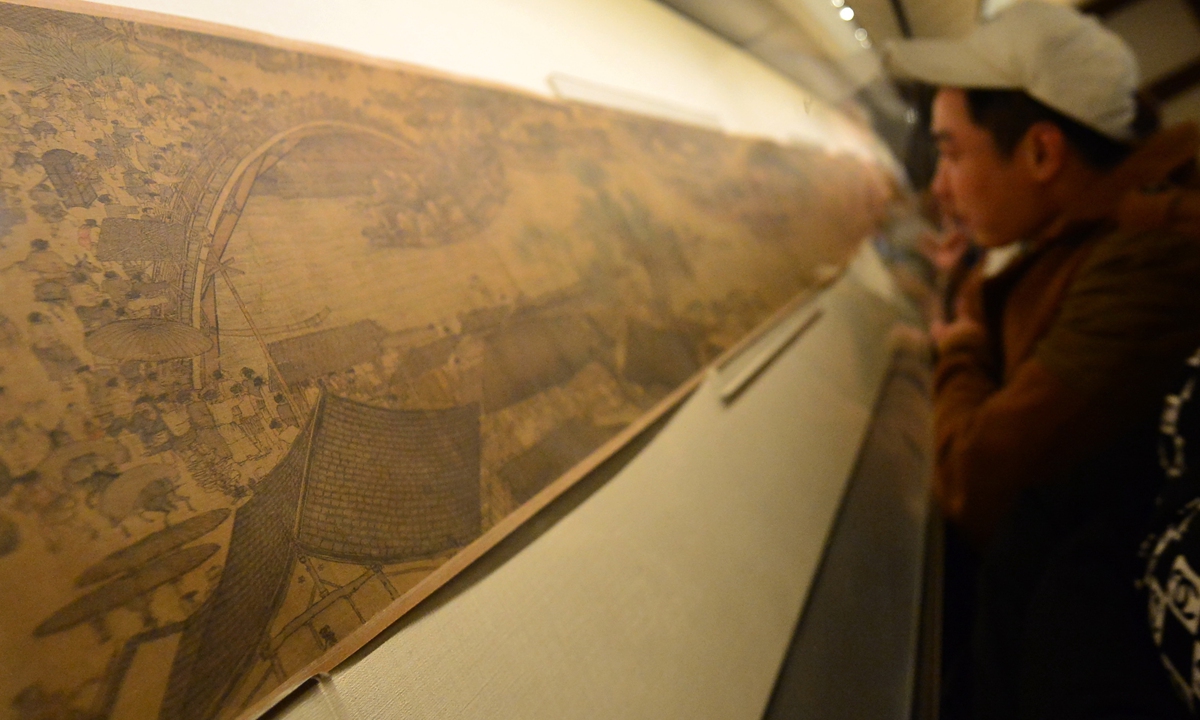 A visitor examines the painting <em>Along the River During the Qingming Festival</em> Photo: IC