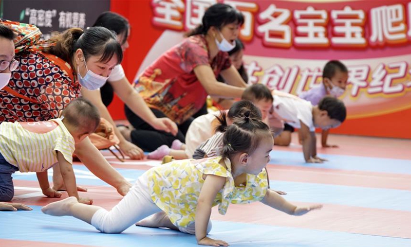 Parents and their babies participate in a baby crawling contest at a shopping center in Daxing District, Beijing, capital of China, Sept. 13, 2020. (Xinhua/Li Xin)
