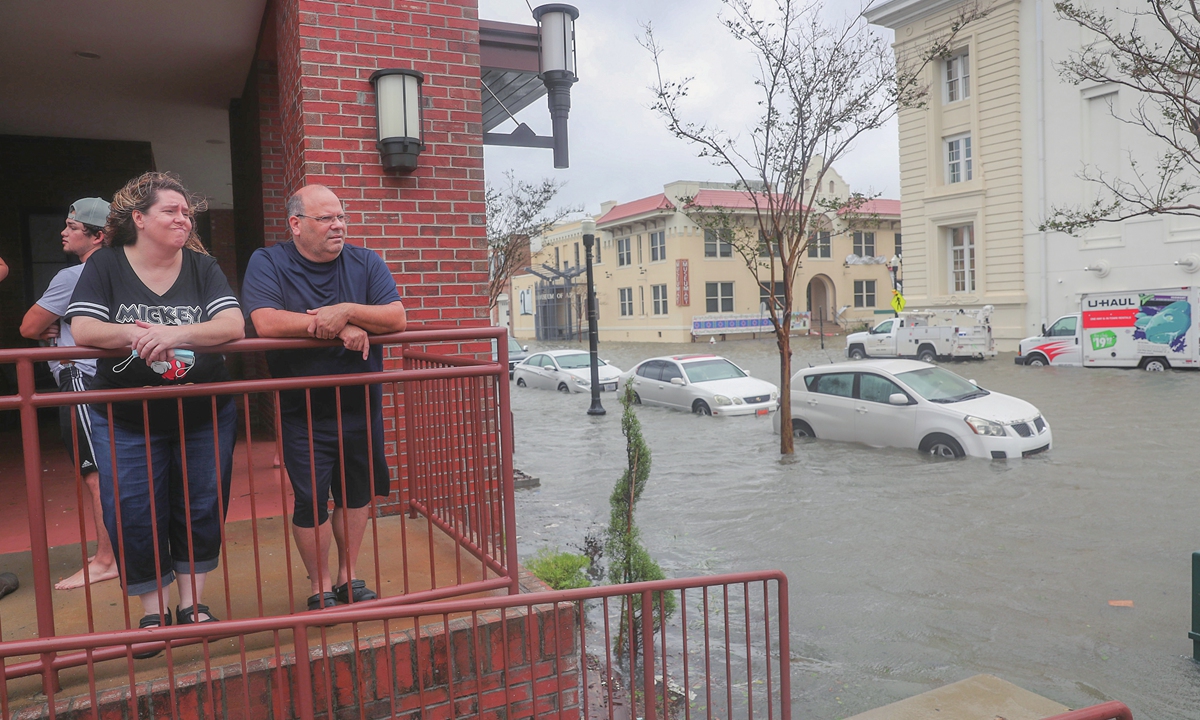 Two Americans peer into a flooded street in front of their hotel as Hurricane Sally passed through the area on Wednesday local time in Pensacola, Florida. The storm is bringing heavy rain, high winds and a dangerous storm surge to the area. Photo: AFP