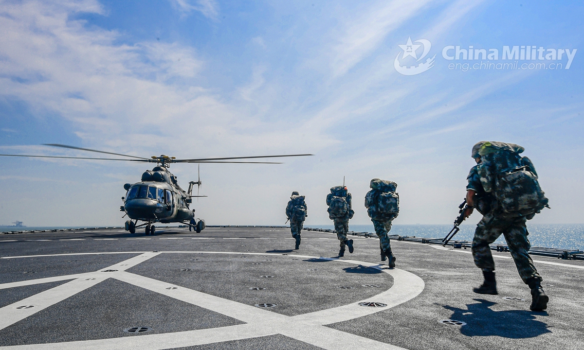 PLA Army soldiers in full combat gears run to board a transport helicopter on the flight deck of the dock landing ship Yimengshan (Hull 988) of the PLA Navy during an inter-Services maritime coordinated training exercise at an undisclosed sea area on August 3, 2020. They are assigned to an army aviation brigade under the PLA 73rd Group Army.File Photo:China Military