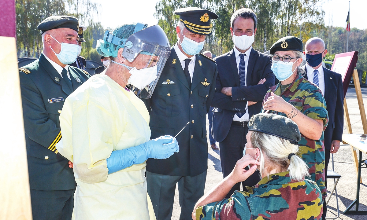 King Philippe of Belgium (center) wears a protective mask as he arrives to observe COVID-19 testing for Belgian defense forces, in Marche-en-Famenne, on Tuesday. Photo: AFP