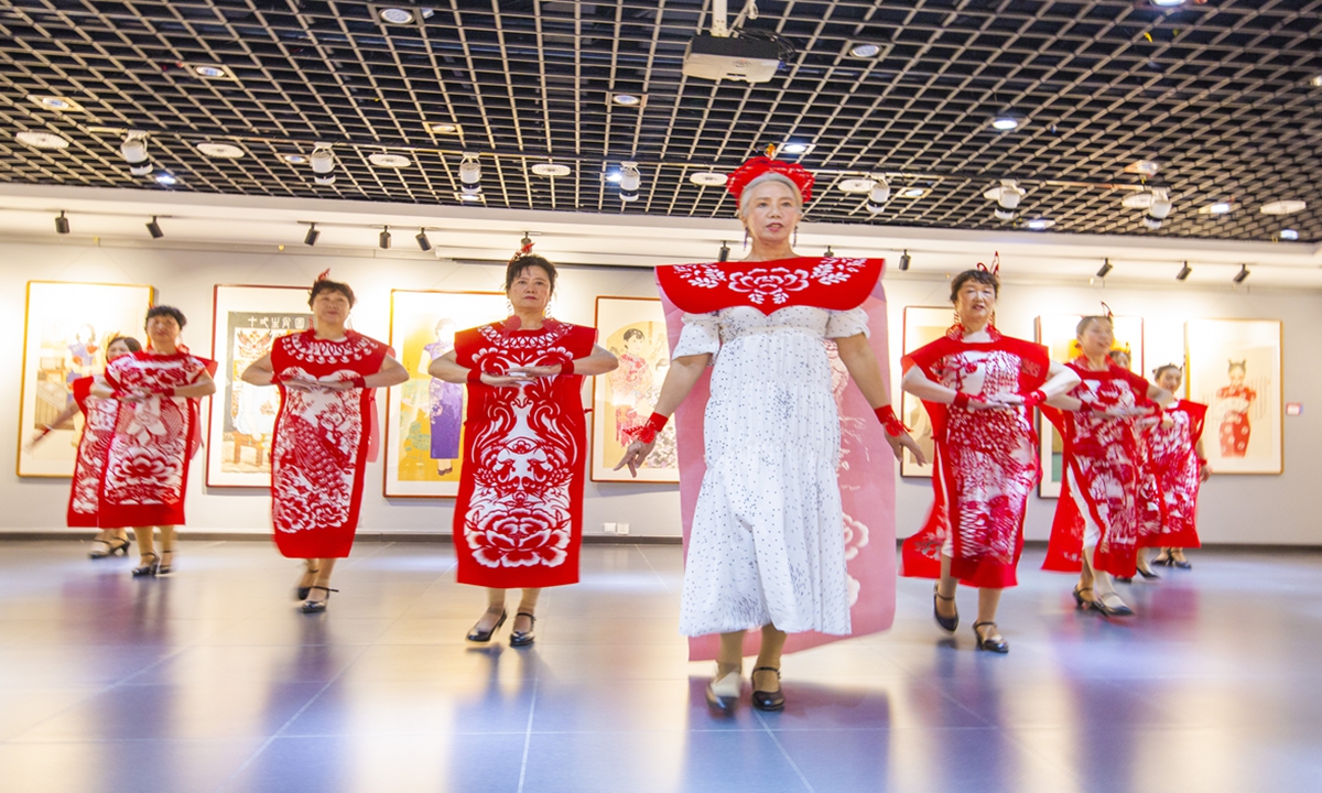 Elder models present paper cut qipao, or Chinese long gown, at an art museum in Shenyang, Northeast China's Liaoning Province on Sunday. Photo: IC